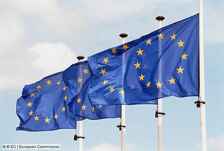 Four flagstaffs flying the EU flag in a row