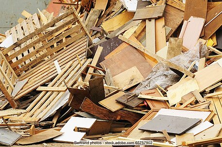 Heap of mixed waste wood, including pallets and pieces of old furniture. 
