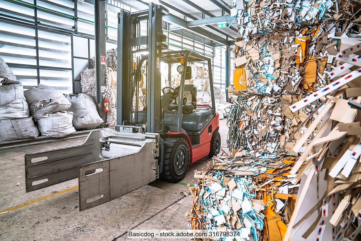Stock photo of a forklift with bale attachment in recovered paper storage building
