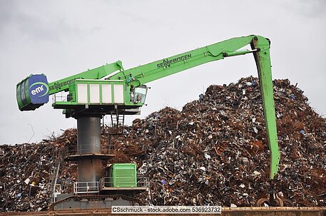 EMR scrap metal operations in Hamburg, green crane atop a quay wall