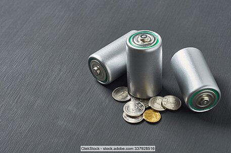 Portable batteries an coins on a dark surface