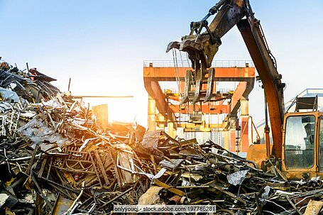 Illustrative photo showing a pile of metal scrap in a port and a crane.