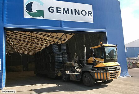 Baled waste being transported on a trailer at a Geminor storage facility