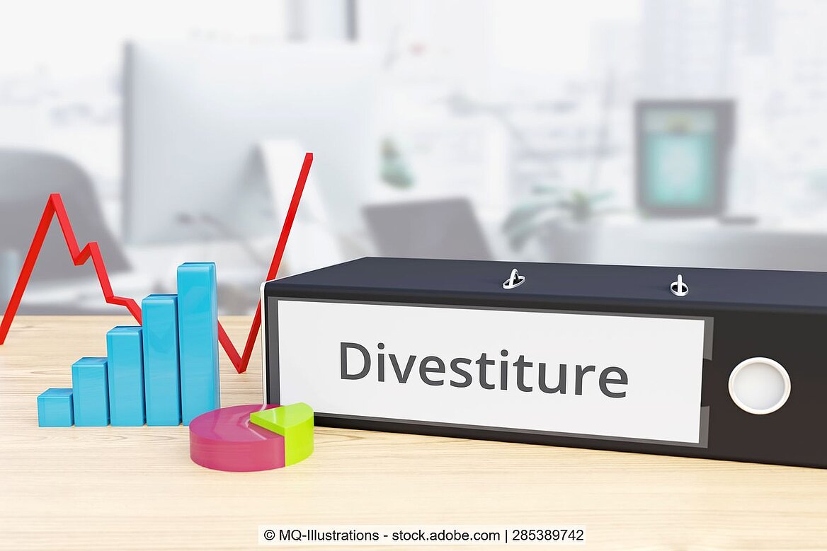 A folder labelled Divestment lies in front of a chart.