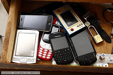 serveral old mobile phones lying in an open drawer stockphoto