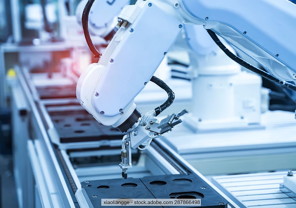 Robotic arm assembles electronic equipment, stock photo