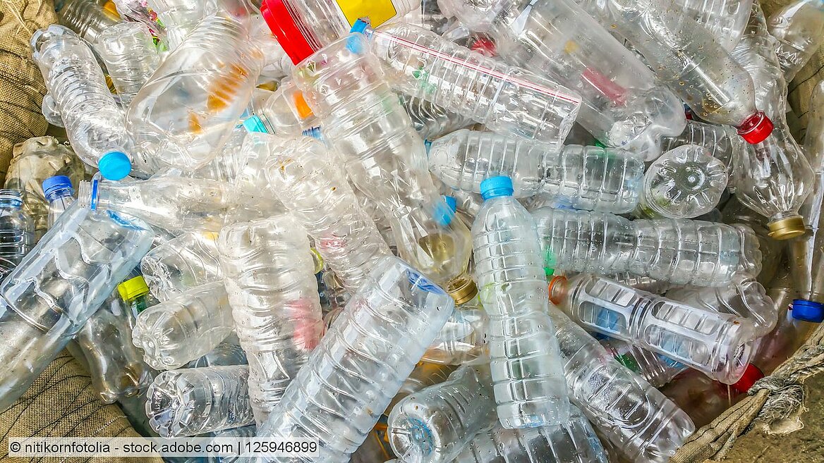 Stock photo of clear natural PET bottles with closures in different colours