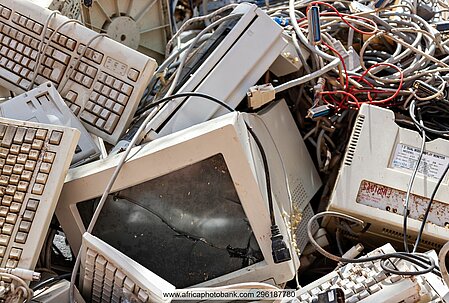 An old cathode-ray tube (CRT) computer monitor, surrounded by keyboards and cables
