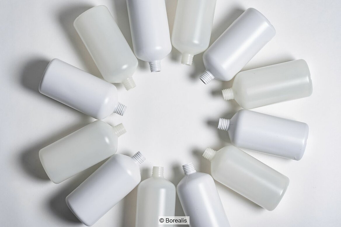 White and clear plastic bottles arranged in a circle and lying against a white backgrouncle