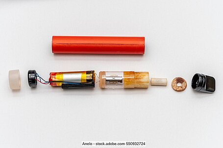 Disassembled components of an e-cigarette on white background.