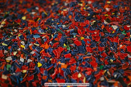 Plastic regrind in mixed colours, mainly red and blue. 