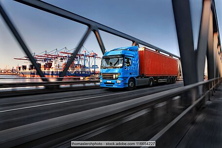 Lorry with container on a bridge with the port of Hamburg in the background
