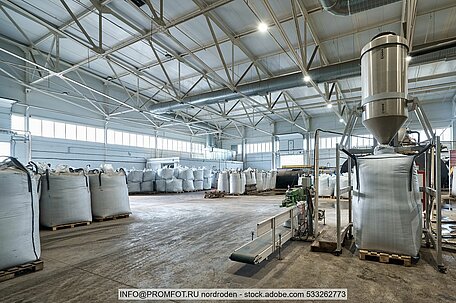 Interior view of warehouse with big bags containing recycled plastic pellets on pallets