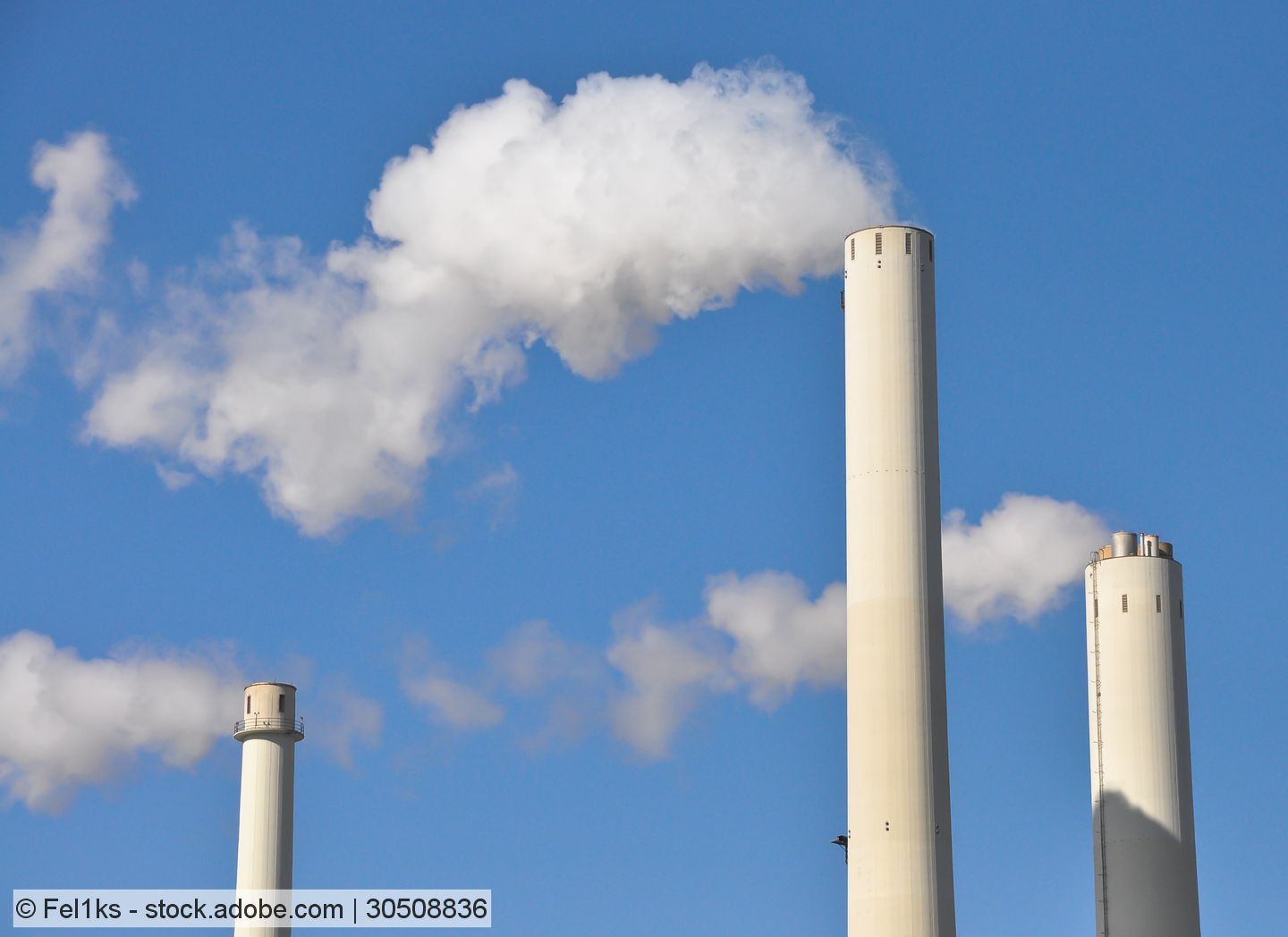 Stock photo of three tall stacks with steam plumes