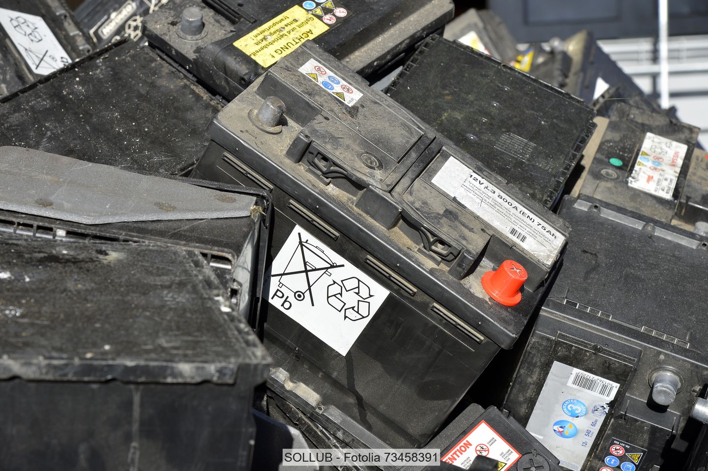 Used lead acid batteries piled in a collection bin