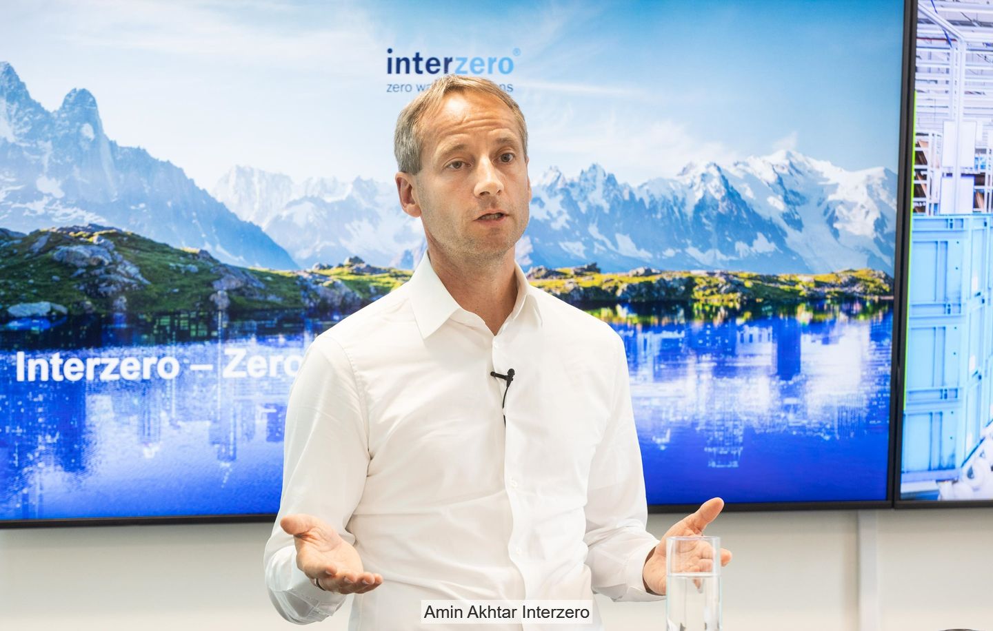 Axel Schweitzer stands in front of a screen emblazoned with the "Interzero" logo