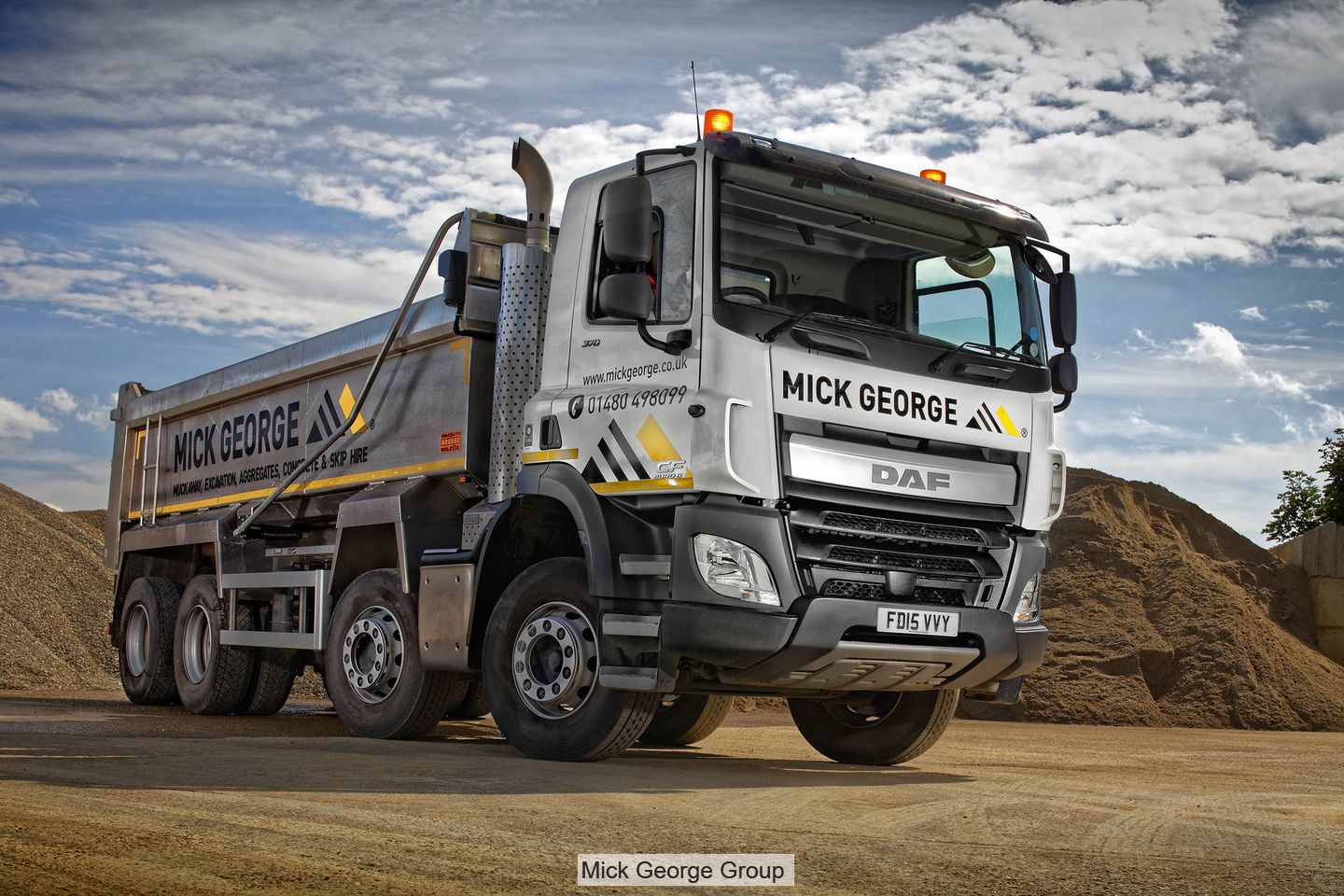 Mick George Group lorry standing in front of heaps of gravel and sand