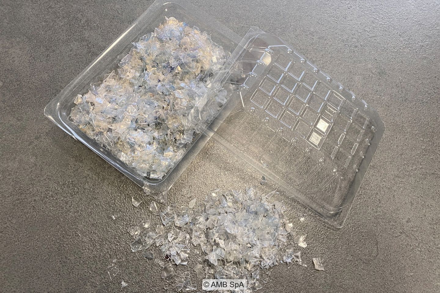 Transparent PET flakes in a transparent tray.